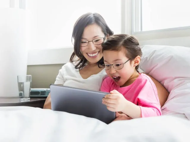 メガネをかけた子供がタブレット端末を笑顔見ている様子